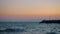 Evening waterscape with wavy sea, rocky pier and flying gull