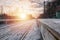 Evening winter landscape with the railway station. Snow-covered railway platform under the sun light at sunset. A place where peo