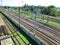 Evenly laid railroad rails crossing the frame diagonally. Railroad track, viewing platforms, rails for repairs, behind the fence.