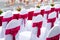 Event chairs with white and red decoration lined up in row