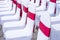 Event chairs with white and red decoration lined up in row