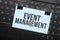 Event Management inscription on white paper note on laptop keyboard. Closeup message