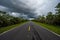 Everglades National Park road receding into distance under stormy cloudscape