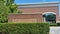 Evergreen shrubs and hedge in front of red brick wall