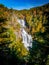 Evergreen trees frame the fall foliage and Whitewater falls in NC