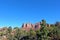 Evergreen trees in front of red sandstone and white limestone mountains in Sedona, Arizona