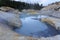 Evergreen trees seem to challenge the slippery slopes close to the dangerous boiling springs and hot mud pots at Lassen Volcanic