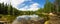 Evergreen woods around lake of Estes Park panorama