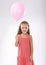 Every childs favorite. Portrait of a young girl holding a pink balloon.