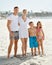Every family deserves a great vacation. A happy young family standing on the beach while on vacation.
