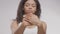 Everyday beauty procedures. Young defocused african american lady applying hand cream on palms, focus on female hands