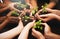 Everyday should be Earth Day. a group of people holding plants growing out of soil.