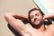 Everyday should be like this. An attractive young man relaxing on the beach sand.