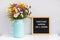 Everything happens for a reason. Motivational quote on letter board and bouquet colorful flowers on white table against