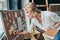 Everything must be planned. Attractive young woman writing something down on the adhesive note while standing in the workshop