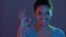 Everything's okay. Young cheerful african american woman showing OK gesture and smiling to camera in neon lights