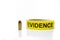 Evidence tape with 9 mm bullet on white background