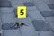 Evidence with yellow CSI marker for evidence numbering on the residental backyard in evening. Crime scene investigation concept