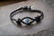 evil eye charm on black leather bracelet