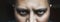 Evil look of angry or tired male with bags or black circles under spooky eyes, close up portrait. Horror creepy demon or