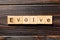 EVOLVE word written on wood block. EVOLVE text on wooden table for your desing, concept