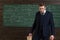 Exacting teacher. Teacher formal wear and glasses looks smart, chalkboard background. Professor exacting and strict