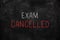 Exam cancelled written with white and red chalk on blackboard