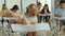 Exam in elementary school. Red-head pupil wearing glasses sits at a first desk in the classroom and fills out tests
