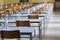 Exam examination room or hall set up ready for students to sit test. multiple desks tables and chairs. Education, school, student