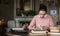 Exam preparation. Student girl in glasses and a pink sweater leaned over books, engaged in an old library at the table.