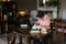 Exam preparation. Student girl in glasses and a pink sweater leaned over books, engaged in an old library at the table.