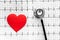 Examine the heart to prevent heart disease. Heart sign and stethoscope on cardiogram background top view