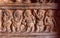 Example of Indian art carvings with dancing party of ancient people on wall of 6th century temples in Badami, India