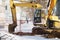 Excavating equipment in a groove on the sidewalk, surrounded by a construction safety net, is prepared for emergency