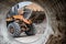 The excavator backfills the pit with the front bucket. Moves soil around the construction site. Close-up. Heavy construction