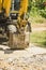 An excavator with a backhoe removes concrete debris from a recently demolished road in a provincial area. Closeup shot of bucket