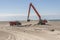 Excavator on the beach in Norre Vorupor, Denmark