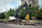 Excavator breaking concrete road surface with hydrohammer drill