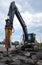 Excavator breaking concrete road surface with hydrohammer drill