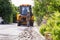 Excavator breaking and drilling the concrete road for repairing. Large pneumatic hammer mounted on the hydraulic arm of a construc