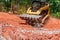An excavator bucket rakes in crushed stone the excavator is picking up a full bucket