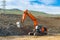 The excavator is building a new road near the power transmission line.