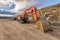 Excavator building a road next to a slope