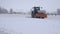 Excavator bulldozer clean snowy horse racetrack in stadium. 4K