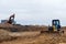 Excavator and a bulldozer work at a construction site. Land clearing, grading, pool excavation, utility trenching and foundation