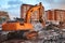 Excavator with concrete crusher on rig at demolition site