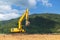 Excavator in construction equipment site on river and mountain and sky background