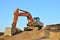 Excavator at a construction site during earthworks and laying of underground pipes.