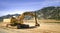 Excavator on a construction site, next to a hill