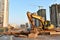 Excavator at a construction site while replacing sewer pipes in the ground. Sewage drainage system for a multi-story building.